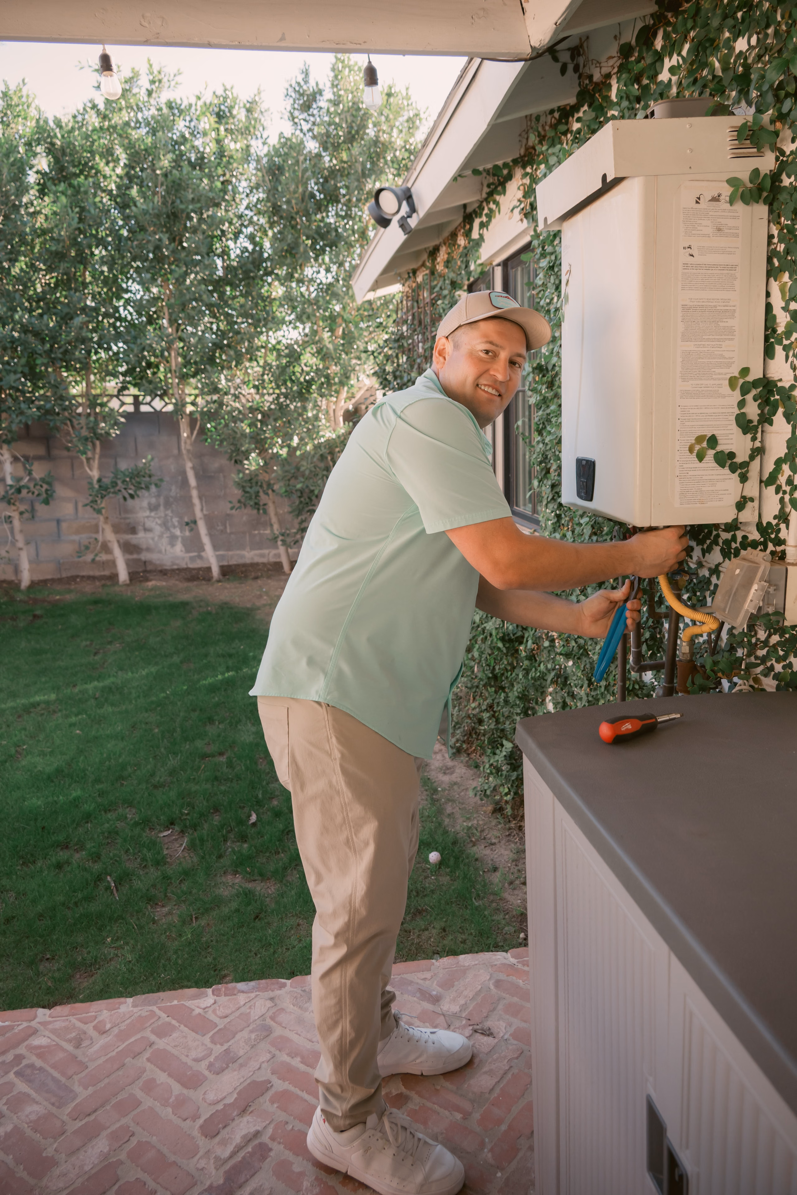 Gabe Sandersius servicing an outdoor water heater
