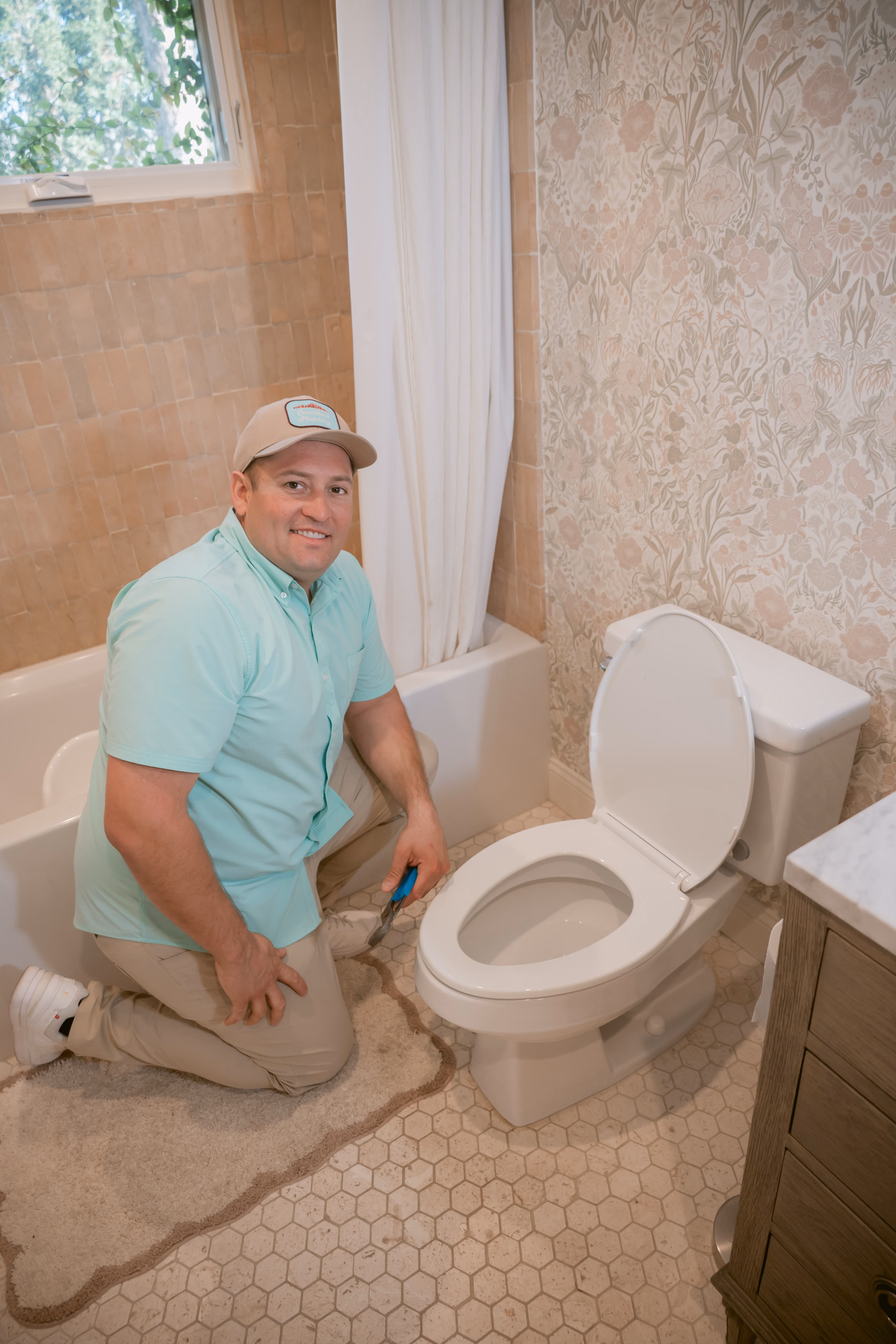 A plumber working on a bathroom toilet fixture
