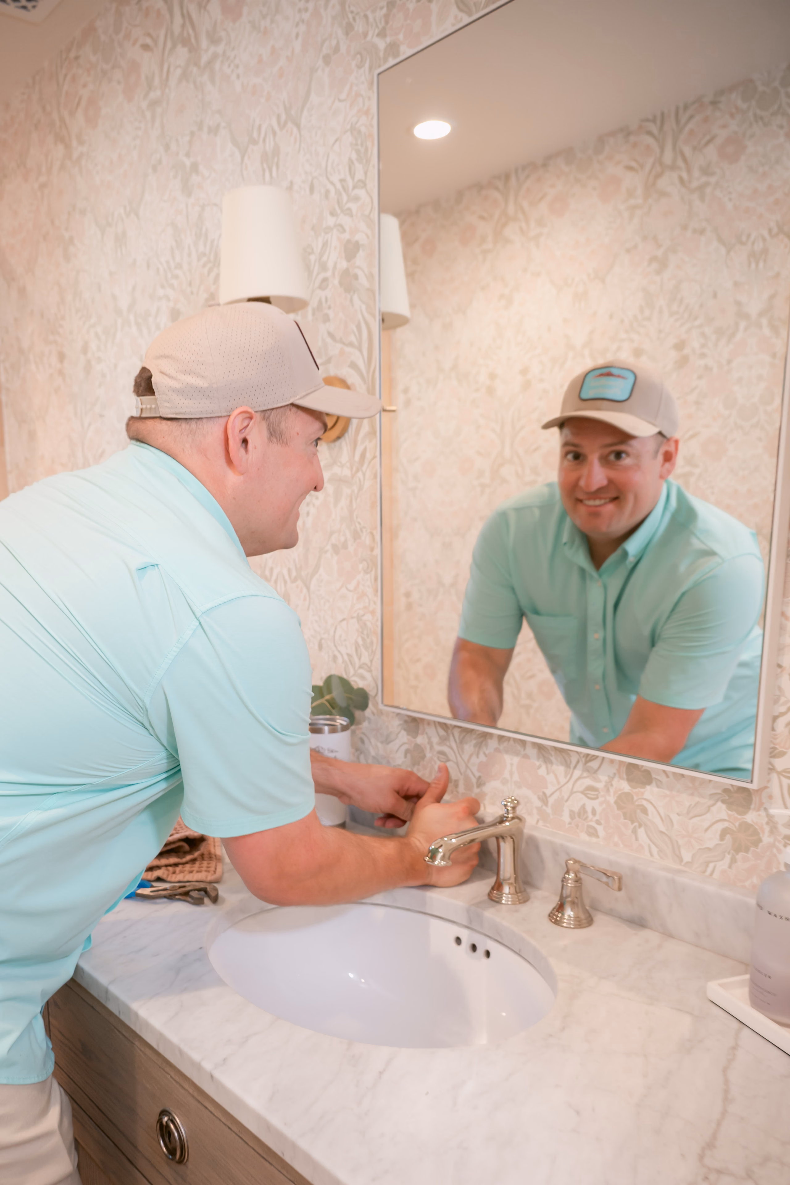 Gabe Sandersius working at a bathroom mirror fixture