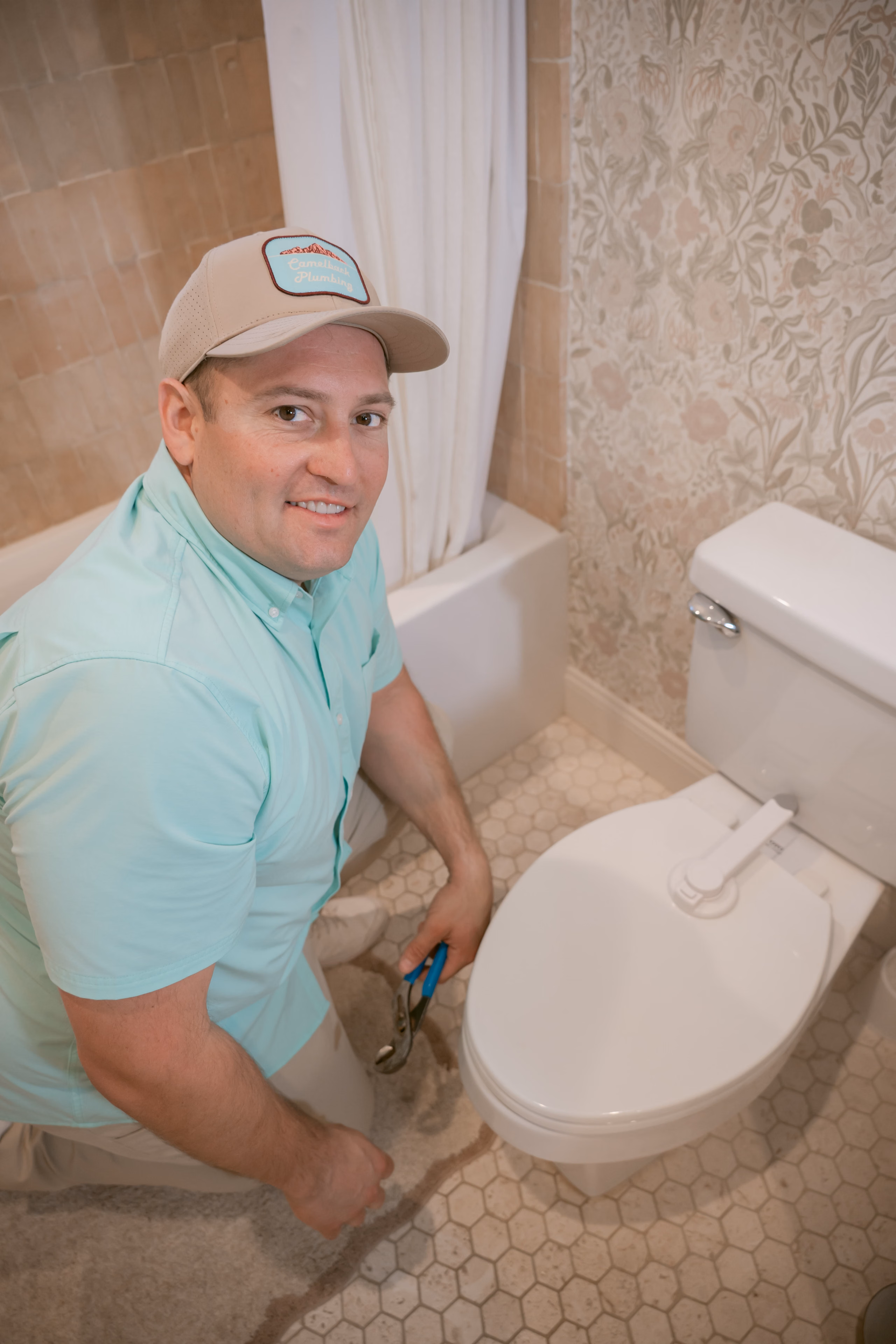A plumber working on a bathroom toilet fixture