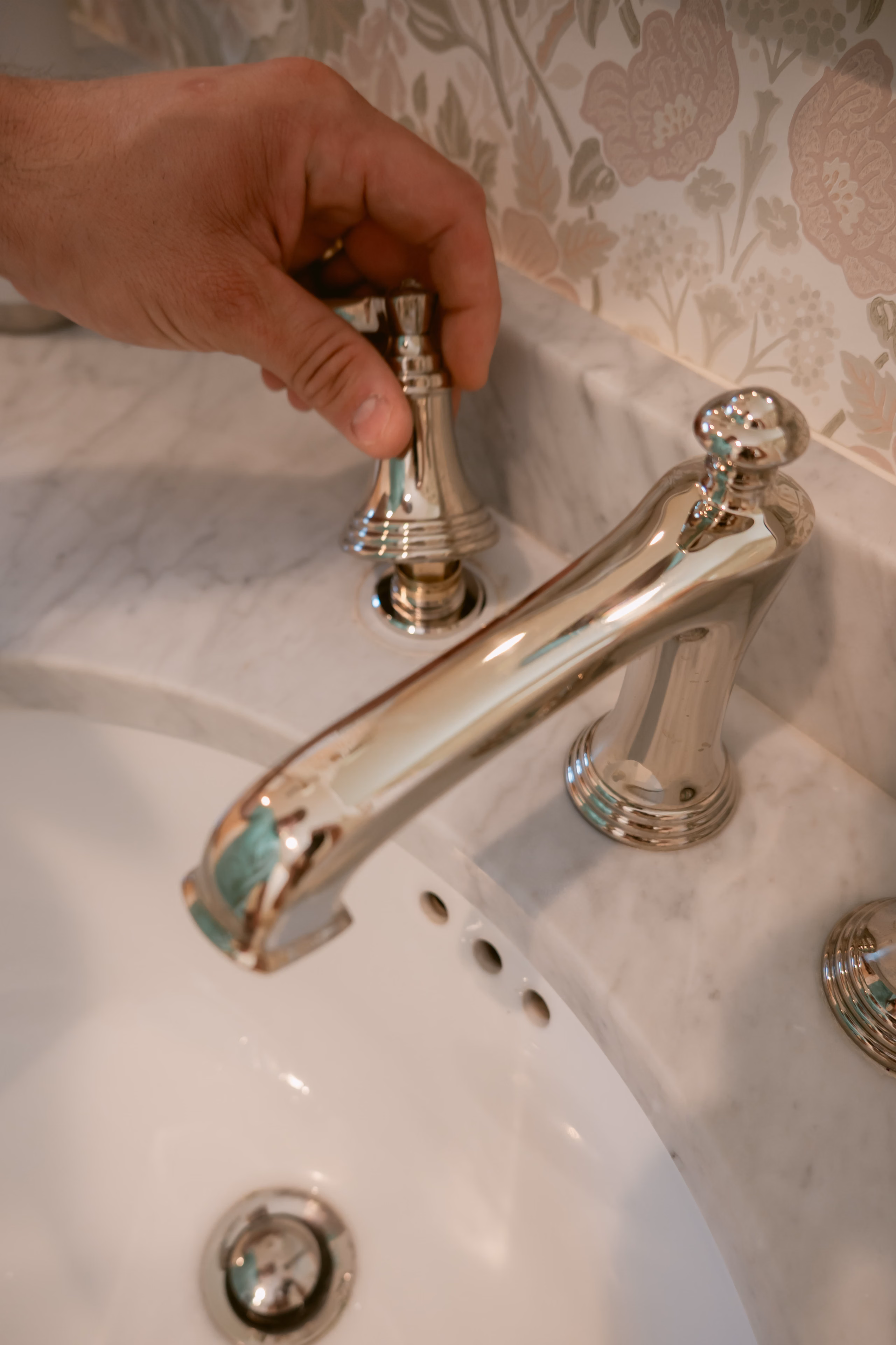 A plumber adjusting a bathroom faucet
