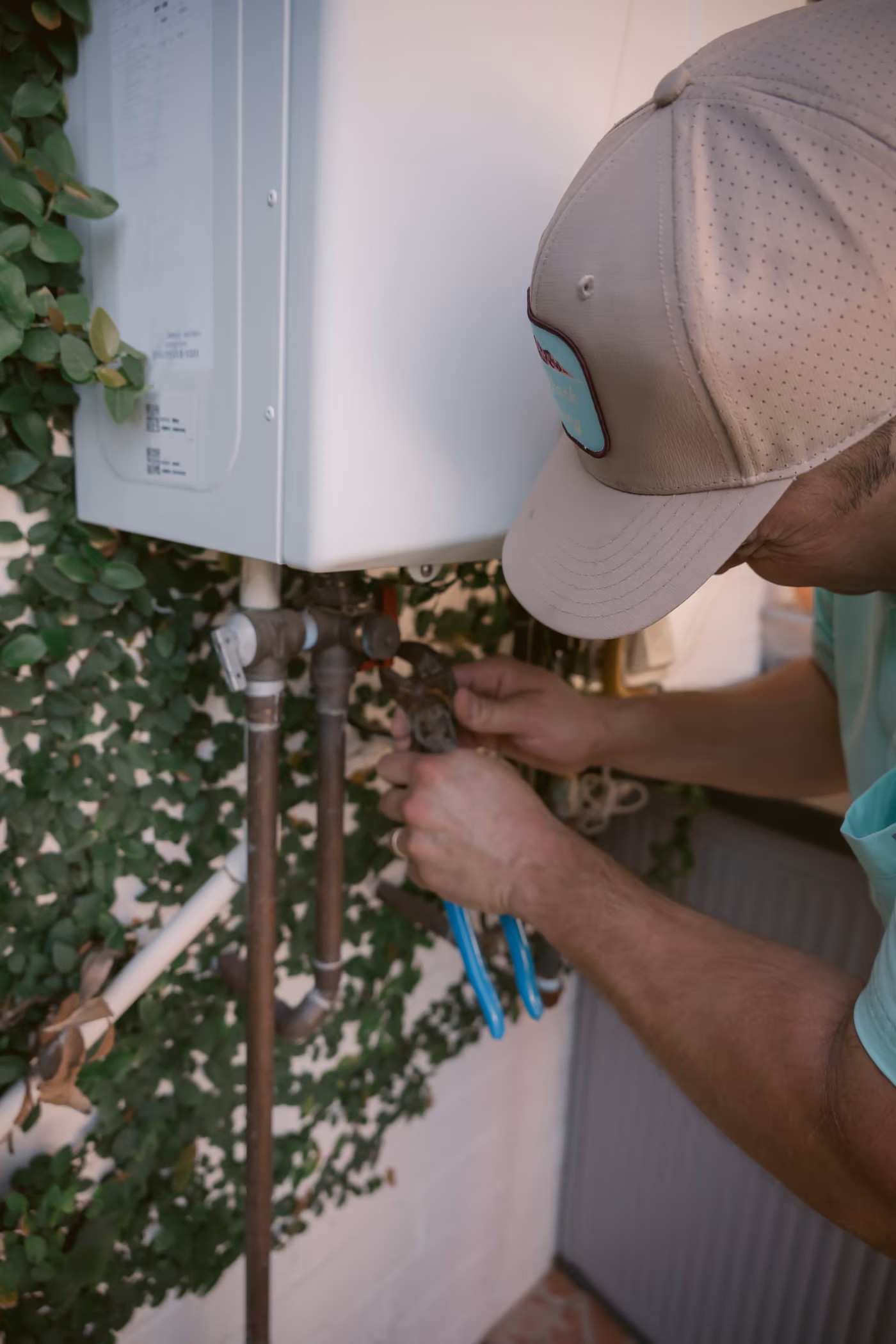 Gabe Sandersius working on an exterior plumbing connection