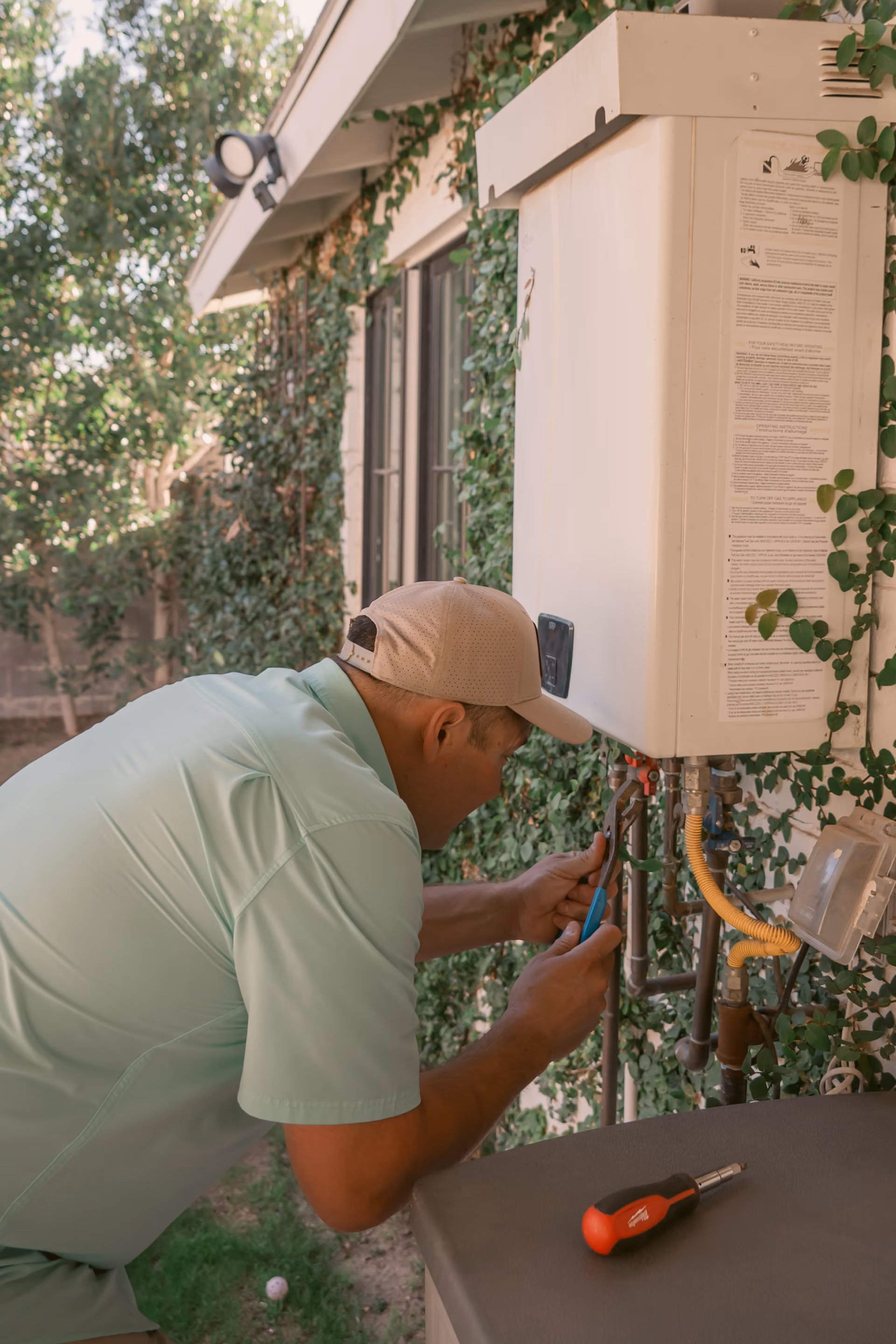 Gabe Sandersius servicing an outdoor water heater